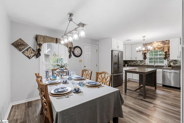 dining room featuring hardwood / wood-style flooring, a chandelier, and sink