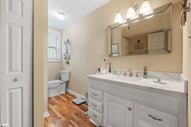 bathroom featuring hardwood / wood-style floors, toilet, and vanity