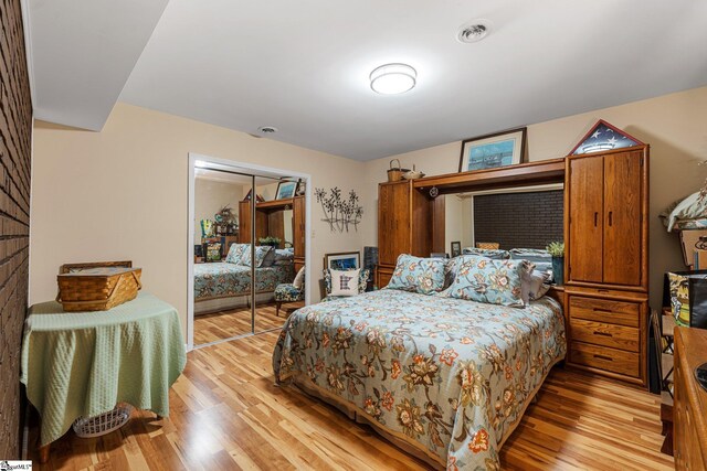 bedroom with light wood-type flooring and a closet