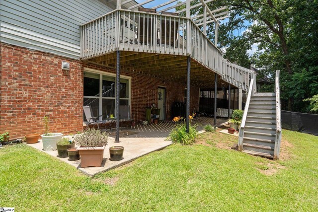 rear view of property with a patio area, a yard, and a wooden deck