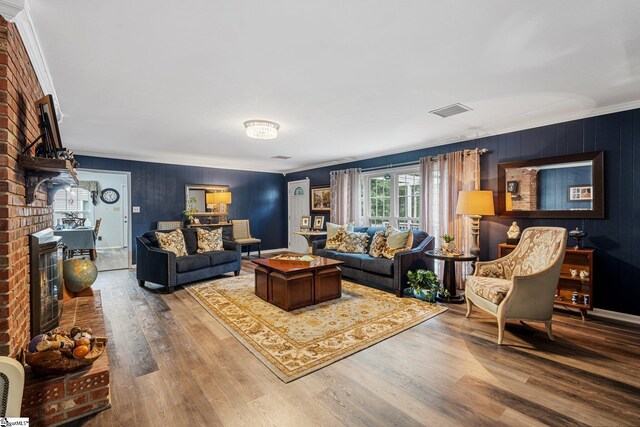 living room featuring crown molding, hardwood / wood-style floors, and a fireplace