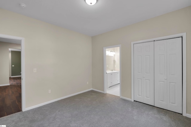 unfurnished bedroom featuring ensuite bath, a closet, and carpet