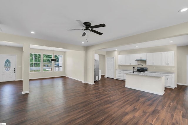 unfurnished living room featuring ceiling fan and dark hardwood / wood-style flooring