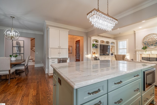 kitchen featuring a center island, an inviting chandelier, crown molding, dark wood-type flooring, and stainless steel microwave