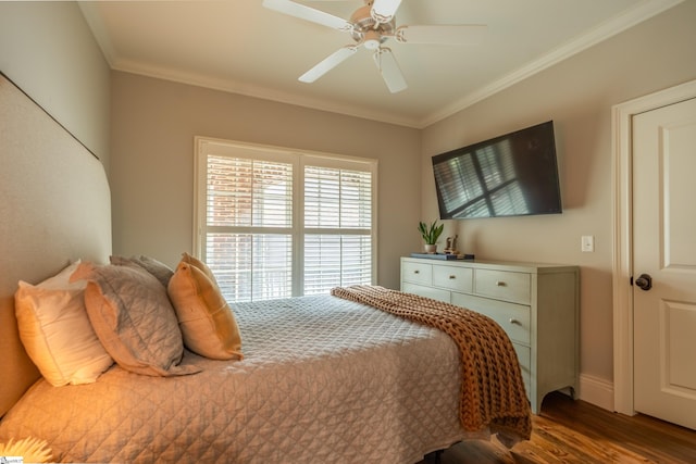 bedroom with a ceiling fan, crown molding, baseboards, and wood finished floors