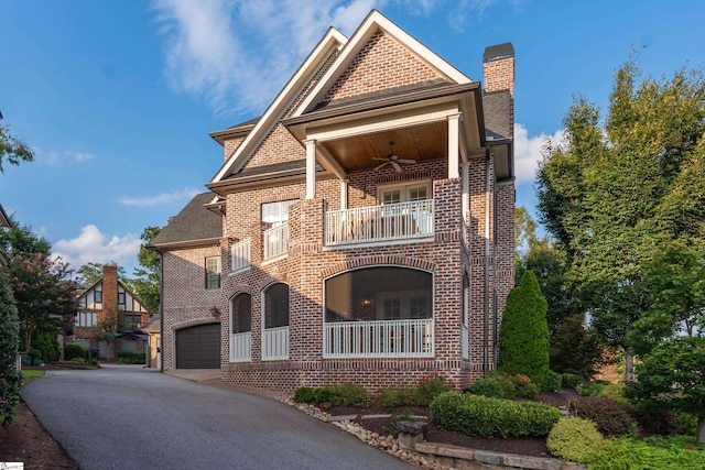 view of front of home featuring a balcony, a garage, and ceiling fan