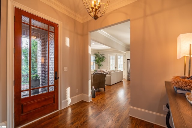 foyer entrance with a notable chandelier, dark hardwood / wood-style floors, and crown molding