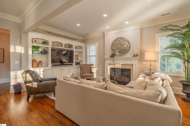 living room with a healthy amount of sunlight, ornamental molding, and hardwood / wood-style flooring