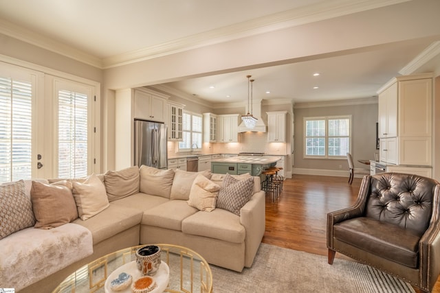 living room featuring a healthy amount of sunlight, ornamental molding, and light hardwood / wood-style floors