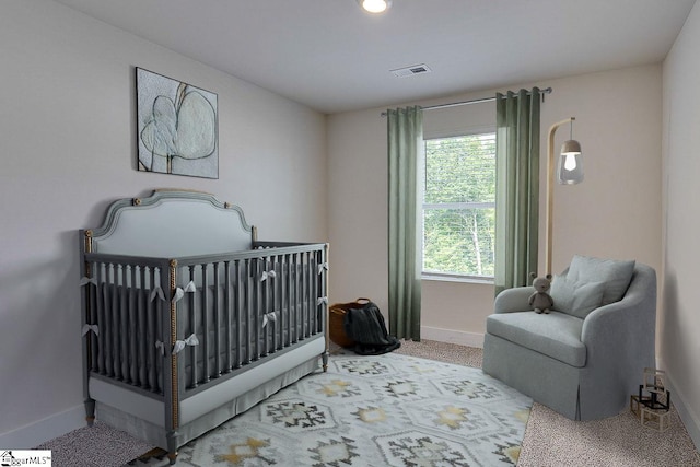 carpeted bedroom featuring a crib