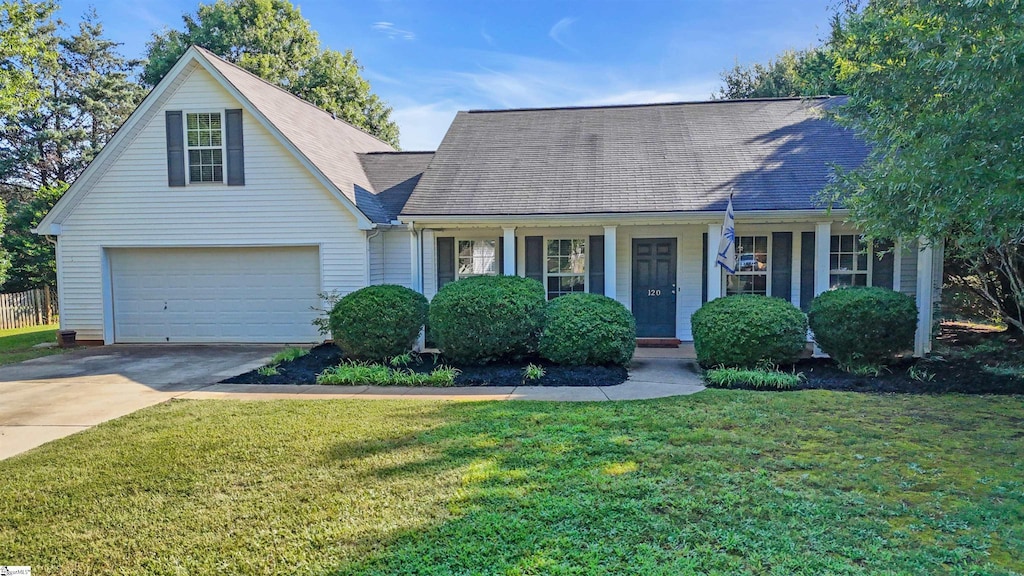 view of front of house featuring a front yard, covered porch, and a garage