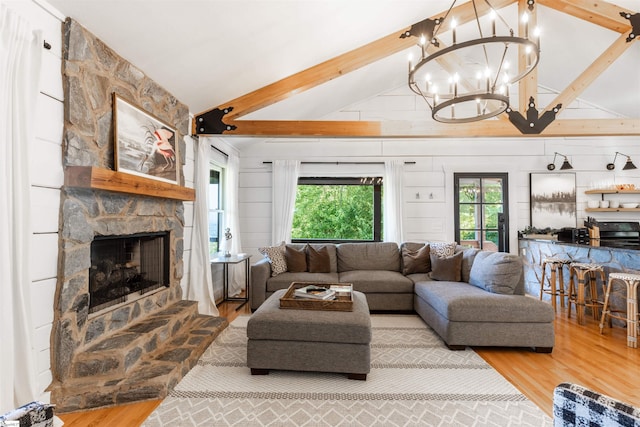 living room with light wood-type flooring, vaulted ceiling with beams, and a fireplace