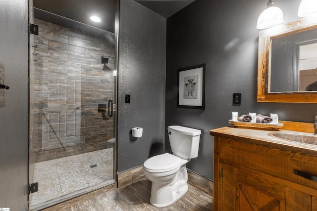 bathroom with vanity, toilet, wood-type flooring, and an enclosed shower