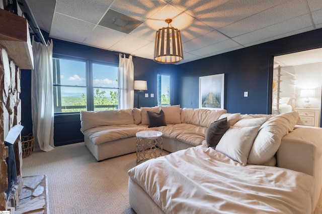 carpeted living room featuring a drop ceiling