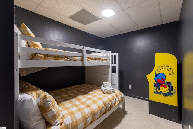 carpeted bedroom featuring a drop ceiling