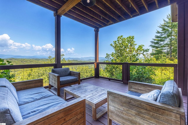 wooden terrace featuring a mountain view and an outdoor hangout area