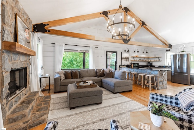 248 Bay View Dr, Salem, SC 29676 - living area featuring light wood finished floors, an inviting chandelier, lofted ceiling with beams, a stone fireplace, and wood walls