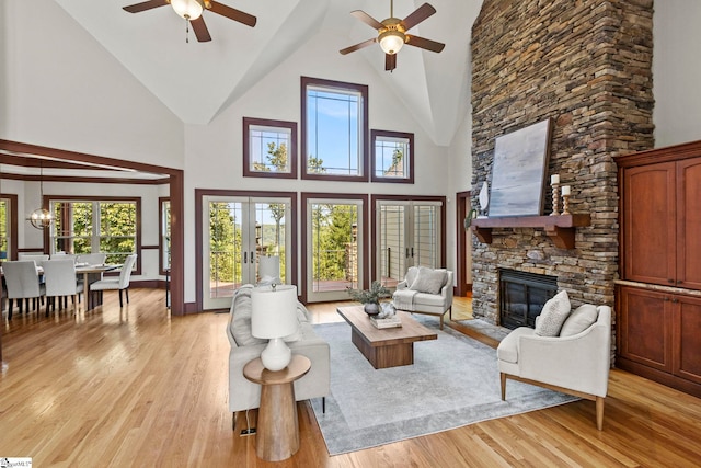 living room with a healthy amount of sunlight, ceiling fan, and a stone fireplace