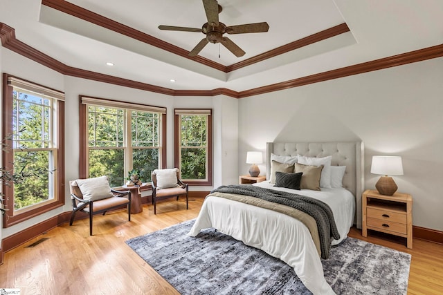 bedroom with ceiling fan, ornamental molding, light wood-type flooring, and multiple windows