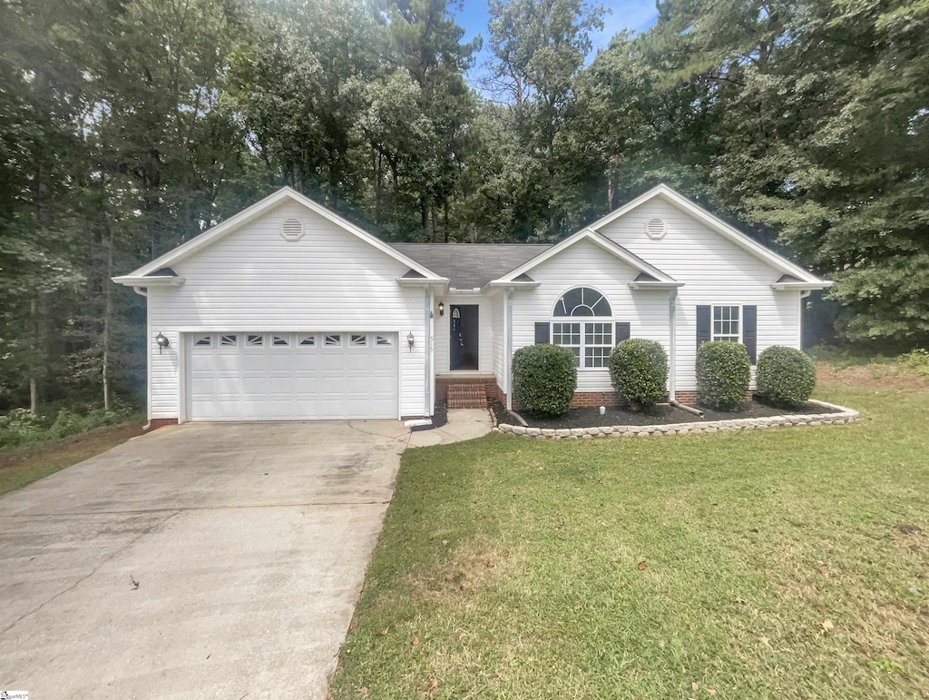 ranch-style home featuring a front yard, concrete driveway, and an attached garage