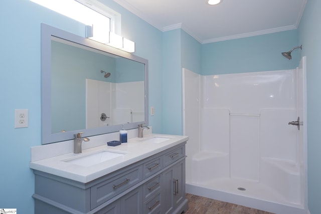 bathroom with hardwood / wood-style floors, walk in shower, crown molding, and vanity