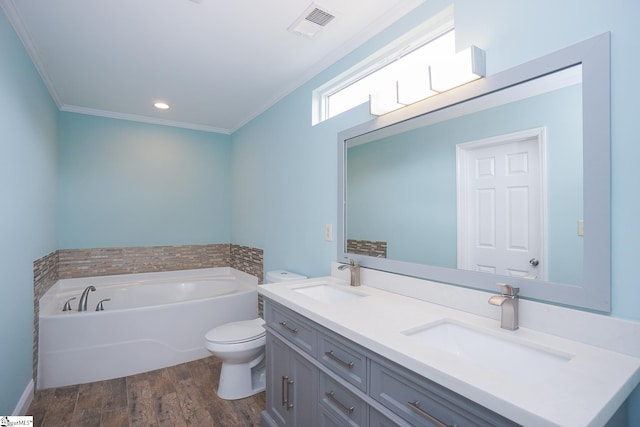 bathroom with crown molding, hardwood / wood-style floors, toilet, a bathing tub, and vanity