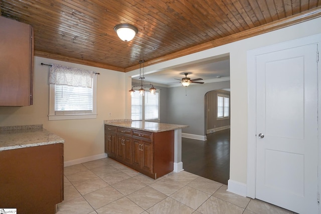 kitchen featuring pendant lighting, light tile patterned floors, kitchen peninsula, light stone countertops, and ceiling fan