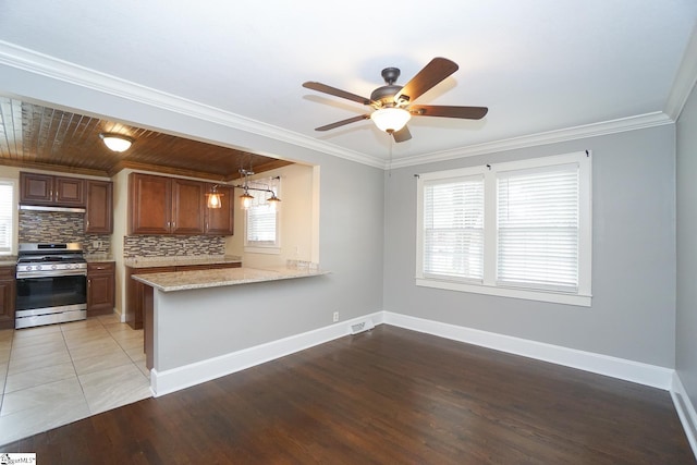 kitchen with ceiling fan, stainless steel range with gas cooktop, light stone countertops, and light hardwood / wood-style floors