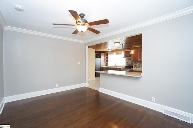 unfurnished living room with ceiling fan, dark hardwood / wood-style floors, sink, and ornamental molding