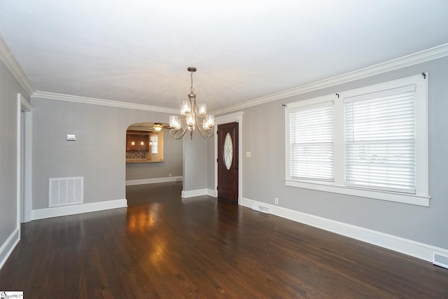 spare room featuring crown molding, dark hardwood / wood-style flooring, and an inviting chandelier