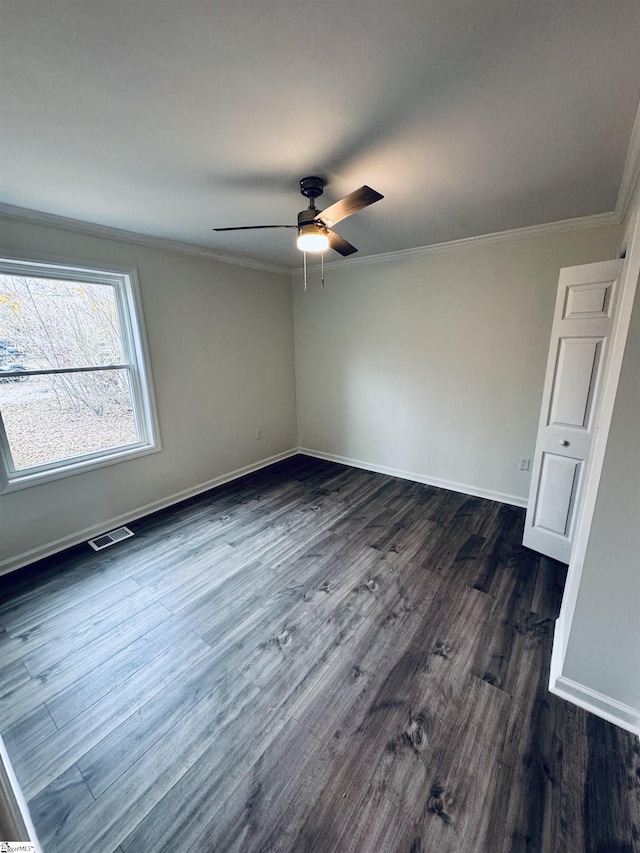 unfurnished room featuring ceiling fan, dark hardwood / wood-style floors, and ornamental molding