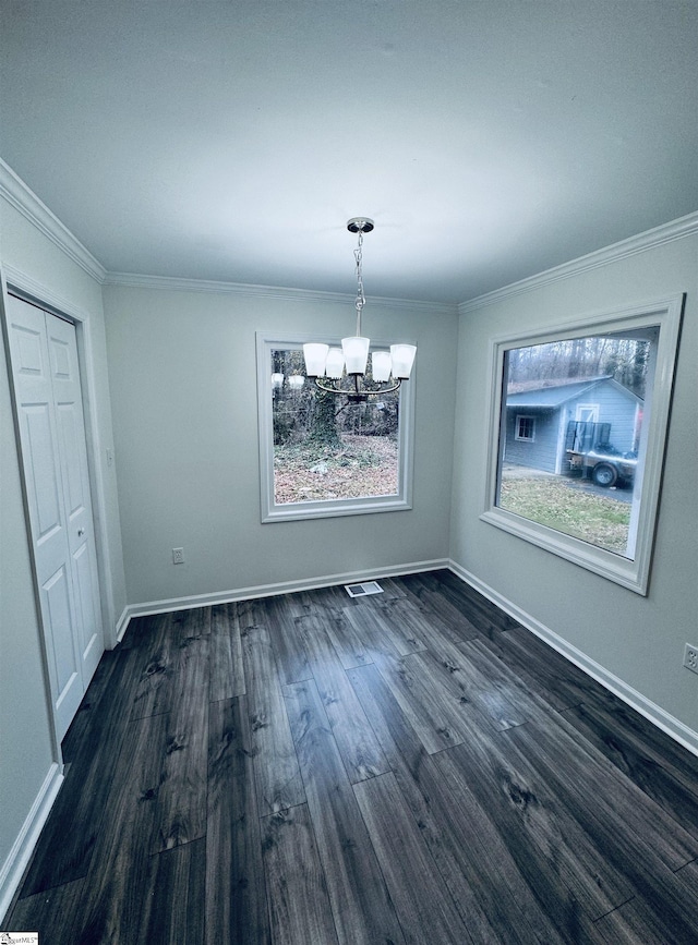 unfurnished dining area featuring crown molding, dark hardwood / wood-style floors, and a notable chandelier