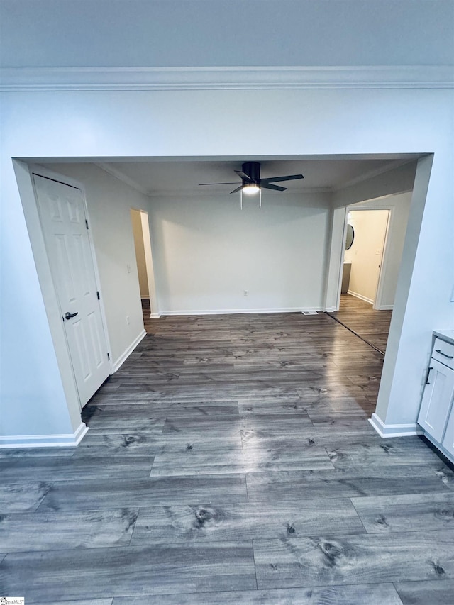 corridor with dark wood-type flooring and crown molding