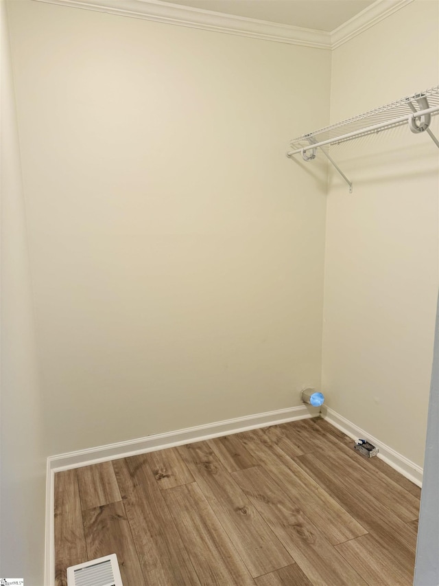 laundry area with hardwood / wood-style floors and crown molding