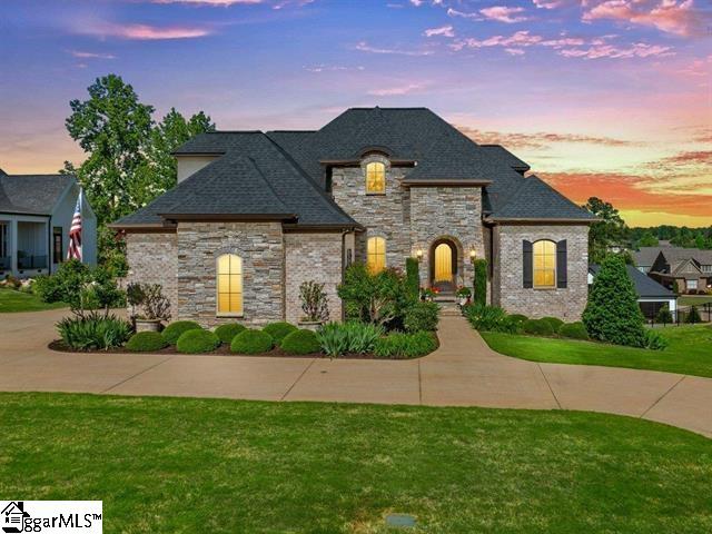 french country inspired facade featuring a lawn