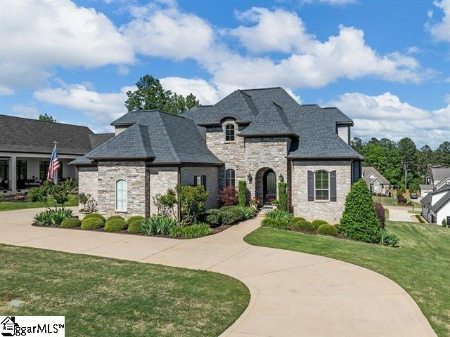 french country style house featuring a front lawn