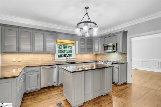 kitchen featuring a kitchen island, gray cabinetry, appliances with stainless steel finishes, and a notable chandelier