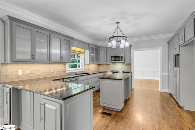 kitchen with a notable chandelier, gray cabinets, appliances with stainless steel finishes, and sink