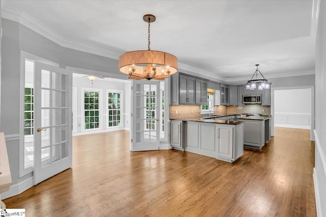 kitchen with hanging light fixtures, hardwood / wood-style floors, an inviting chandelier, and gray cabinets