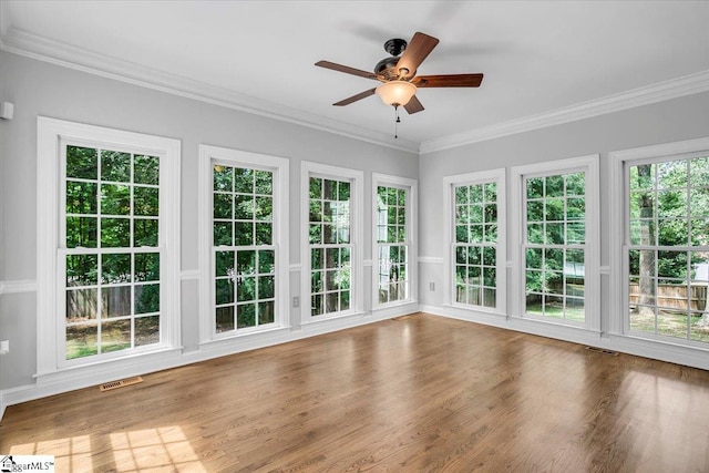 unfurnished sunroom featuring ceiling fan and plenty of natural light