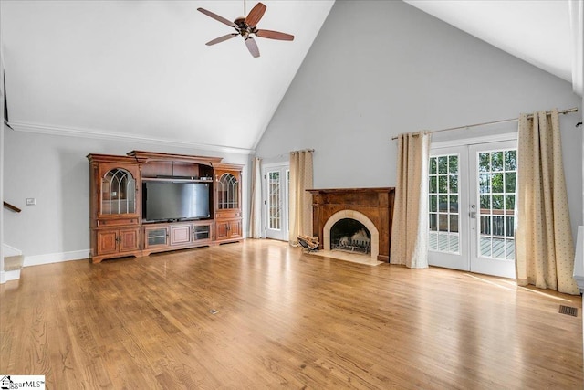 unfurnished living room featuring french doors, high vaulted ceiling, light hardwood / wood-style floors, and ceiling fan