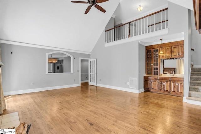 unfurnished living room featuring ceiling fan, high vaulted ceiling, and light hardwood / wood-style floors