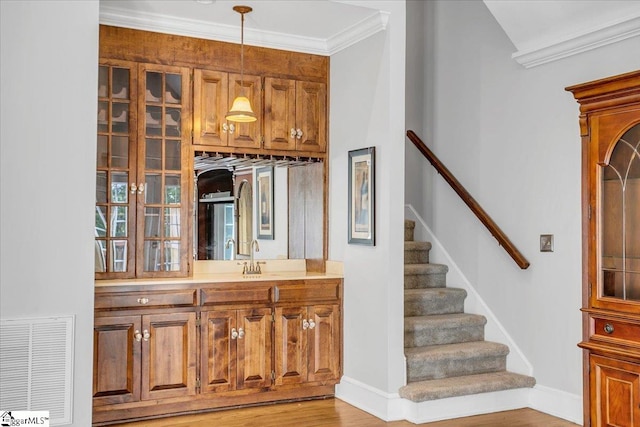 stairway featuring crown molding, hardwood / wood-style floors, and sink