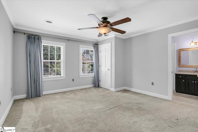 unfurnished bedroom with light carpet, ornamental molding, connected bathroom, and ceiling fan