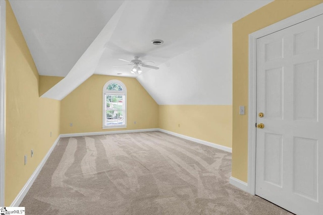 additional living space with lofted ceiling, ceiling fan, and light carpet