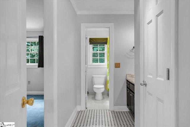 bathroom with plenty of natural light, vanity, toilet, and ornamental molding