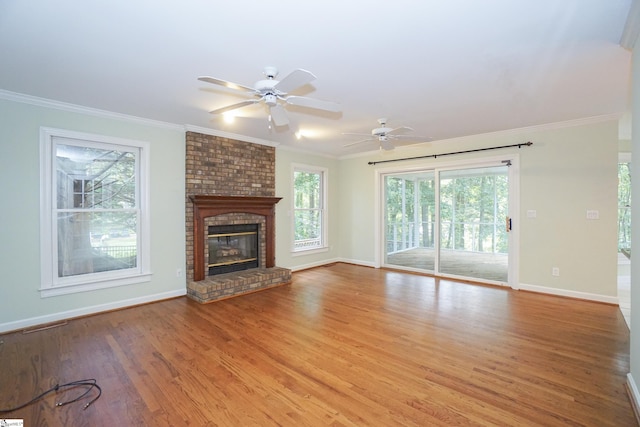 unfurnished living room featuring crown molding, a fireplace, and light wood-type flooring