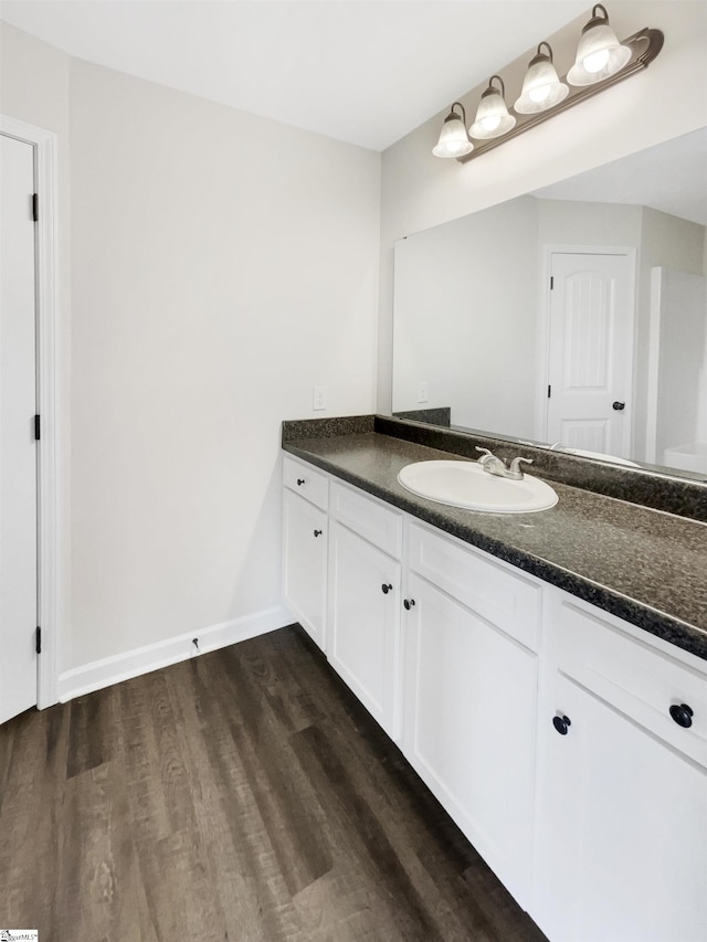 bathroom with vanity, baseboards, and wood finished floors