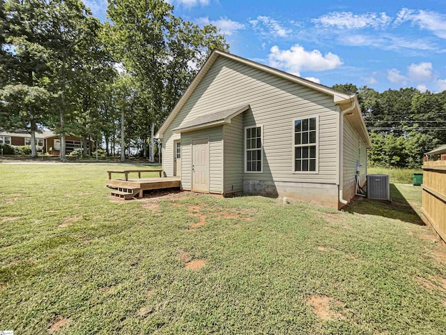 rear view of house with a yard and cooling unit