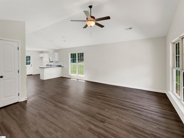 unfurnished living room featuring lofted ceiling, dark wood-type flooring, and ceiling fan